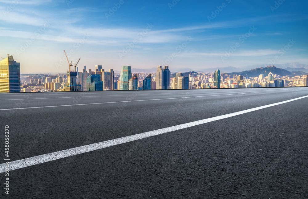 Panoramic skyline and empty asphalt road with modern buildings