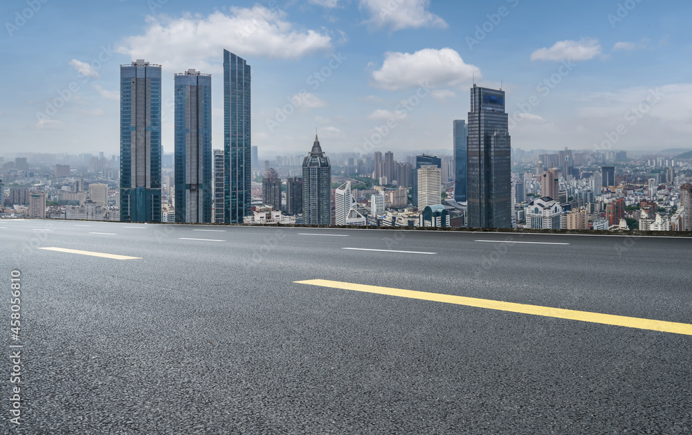 Panoramic skyline and empty asphalt road with modern buildings