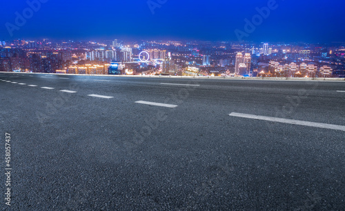 Panoramic skyline and empty asphalt road with modern buildings