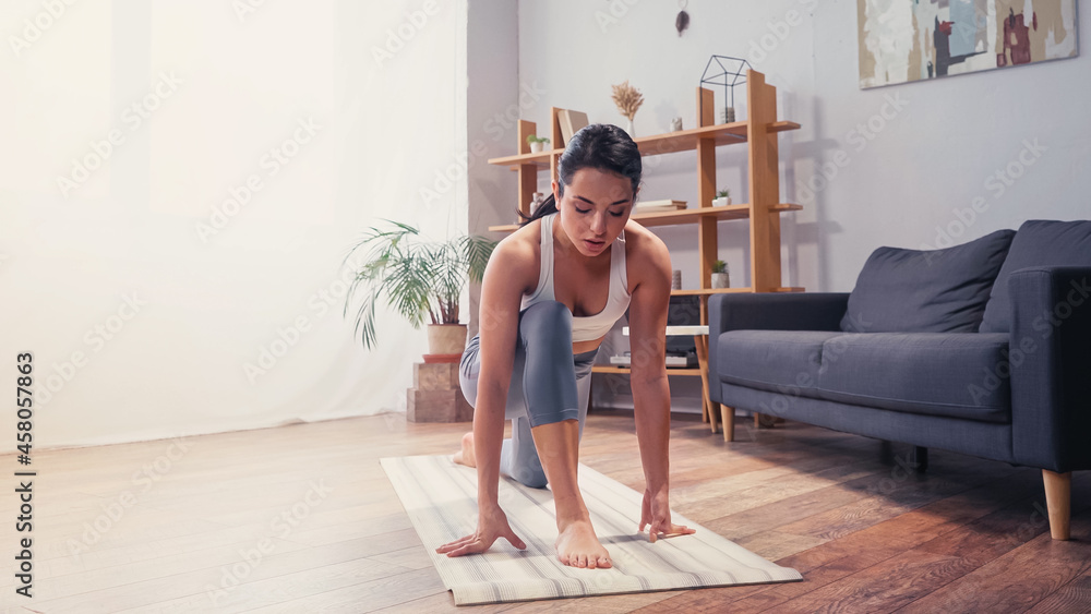 Sportswoman working out on fitness mat at home
