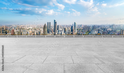 Panoramic skyline and empty square floor tiles with modern buildings