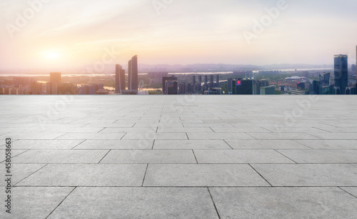 Obraz na plátně Panoramic skyline and empty square floor tiles with modern buildings