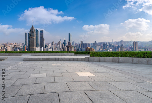 Panoramic skyline and empty square floor tiles with modern buildings