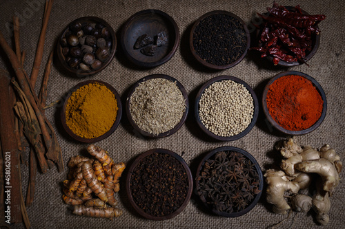 Spices in an earthenware jar with a burlap base