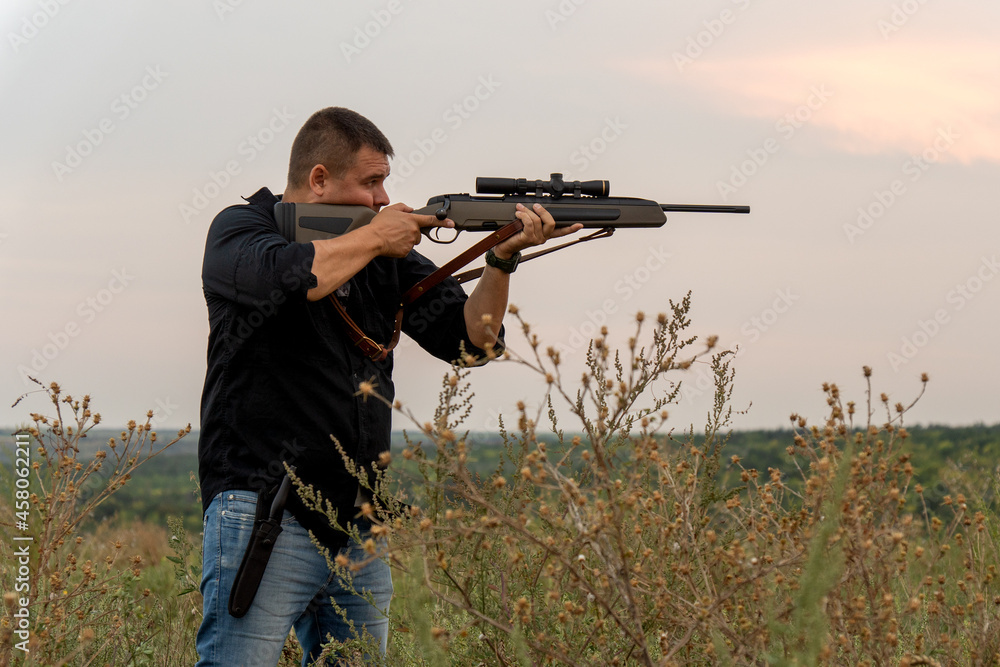 European shoots a rifle with a optics sight. Portrait of a shooter with a rifle European shoots a rifle with a optics sight. Portrait of a shooter with a rifle