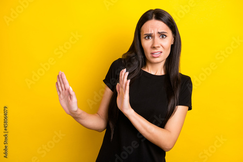 Photo portrait of girl in black t-shirt disgusted refusing ignoring isolated vibrant yellow color background