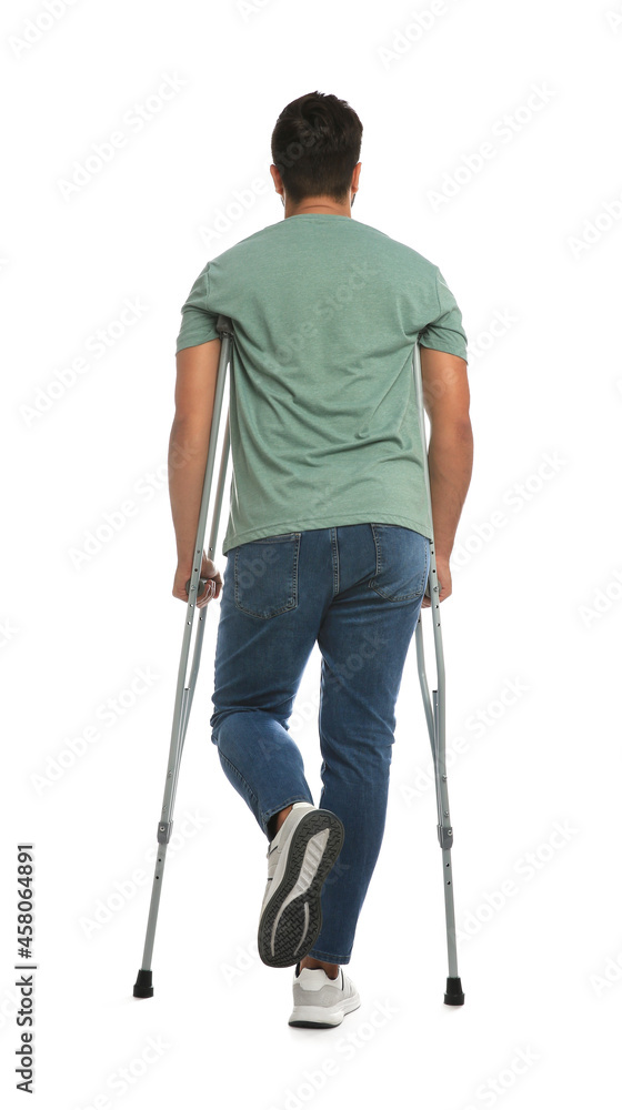 Young man with axillary crutches on white background, back view Young man with axillary crutches on white background, back view