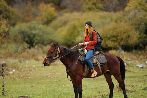 woman hiker riding a horse on nature travel
