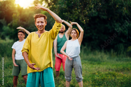 Outdoor group qigong practice with coach.