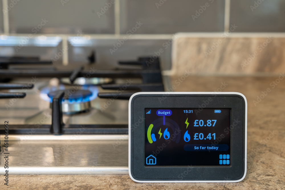 household digital smart meter against a background of a gas flame on a cooker .
