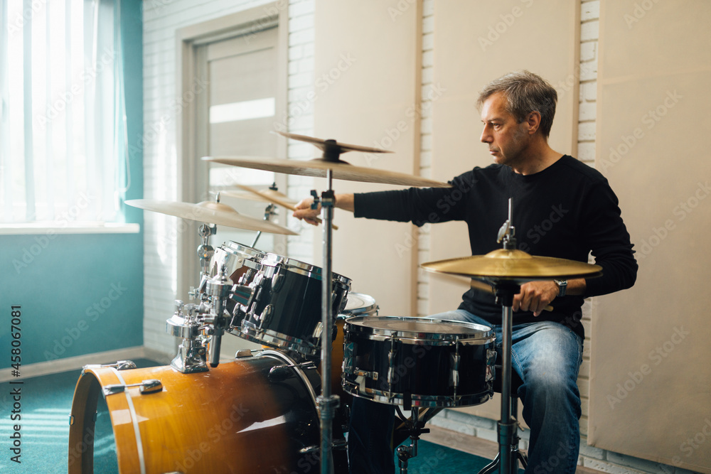  middle-aged man plays drum set