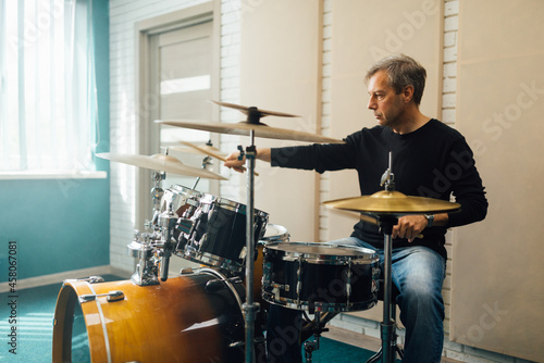  middle-aged man plays drum set