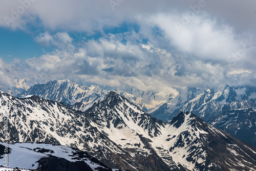 Mountain clouds over beautiful snow-capped peaks of mountains and glaciers. View at the snowy mountains. © Andrei Armiagov