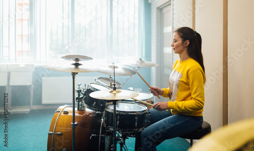 Young girl practicing drumming on drum set