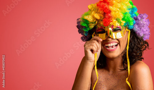 Beautiful woman dressed for carnival night. Smiling woman ready to enjoy the carnival with a colorful wig and mask