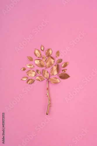 Gold tree on the pink background. Creative composition.