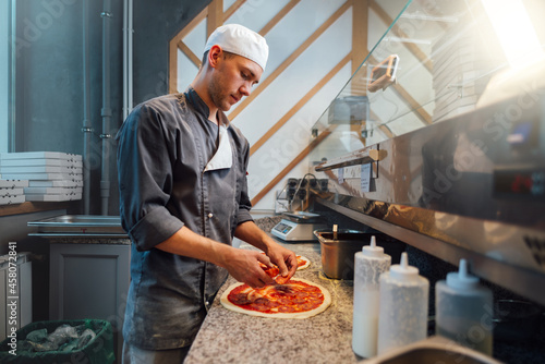 The chef prepares pizza. Catering kitchen work. photo