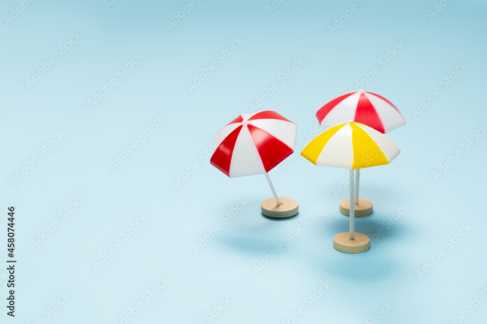 Obraz premium Yellow and red umbrella on a blue background.