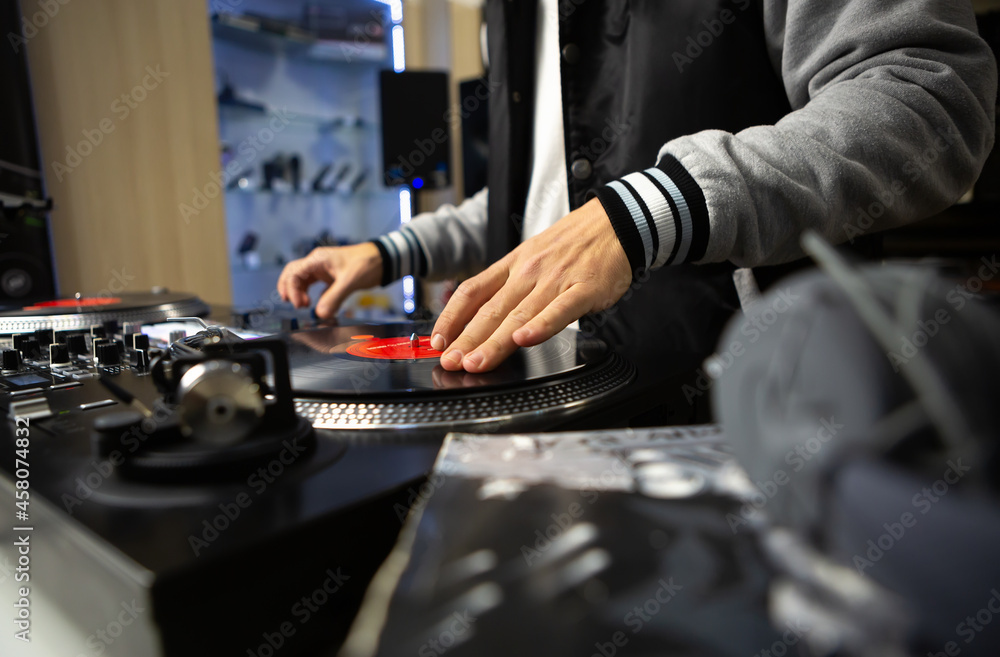 Hip hop dj scratching vinyl record on turn table. Professional disc jockey scratches musical tracks on turntables Hip hop dj scratching vinyl record on turn table. Professional disc jockey scratches musical tracks on turntables