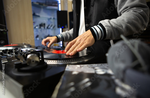 Hip hop dj scratching vinyl record on turn table. Professional disc jockey scratches musical tracks on turntables