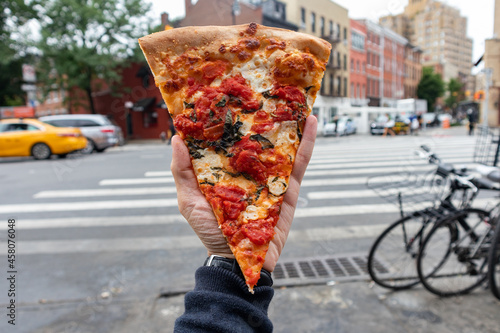 Handheld New York Style Margherita Pizza Slice on a New York City Street © James