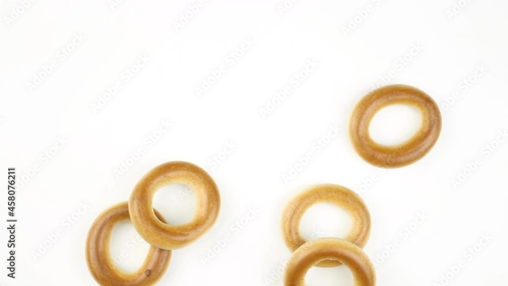 Dry bagels rotating on a white background. Wheat bakery concept, concept of baked breakfast, copy space footage Dry bagels rotating on a white background. Wheat bakery concept, concept of baked breakfast, copy space footage