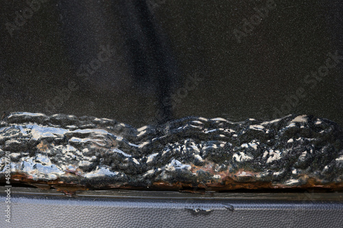 Corrosion of metal on the car body. Rusting car part. photo