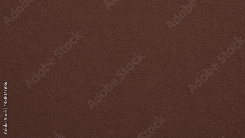The surface of brown cardboard. Paper texture with cellulose fibers. Cafe noir color background. Dark paperboard wallpaper. Textured graceful classic backdrop. Top-down. Macro