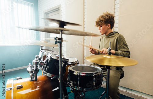 Foto Young teen boy practicing drumming. Drum music school.