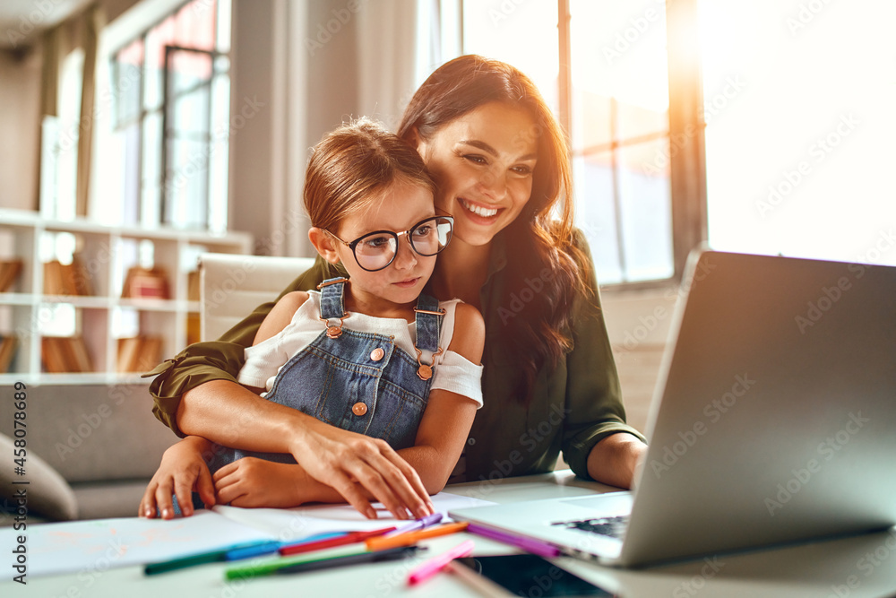 custom made wallpaper toronto digitalBusiness woman and mom working with her little daughter at a laptop. Freelance, work from home.
