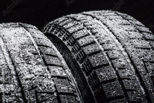 Winter Car tires with snow close-up wheel profile structure on black background