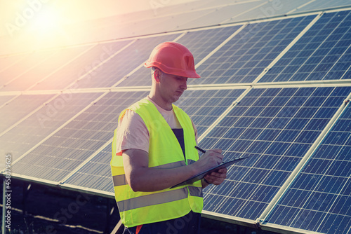 young caucasian man in uniform works at a solar station