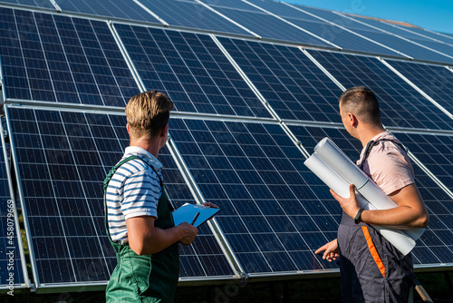 Two man finished installation of new solar panel station