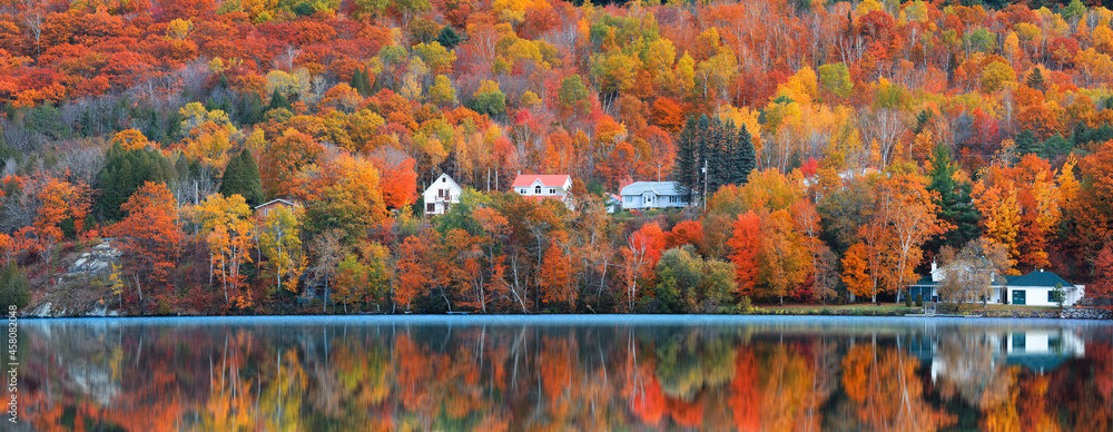 Fototapeta premium Panoramic view of Saint-Jean-des-Piles village surrounded with bright fall foliage in Quebec, Canada