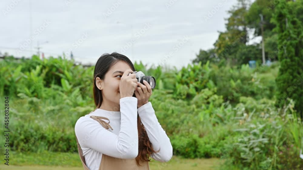 Asian woman with retro camera taking photo of landscape nature on mountain in rainforest Asian woman with retro camera taking photo of landscape nature on mountain in rainforest