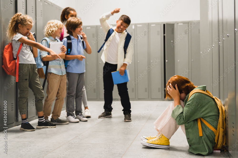 Angry cruel teenagers laughing at their classmate. Elementary school age bullying at school. Social inequality problem. Schoolchildren baiting - obrazy, fototapety, plakaty 