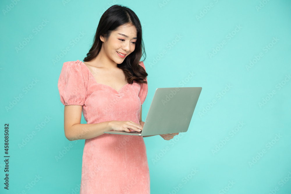 Young Asian business woman using laptop computer on hand isolated on green background Young Asian business woman using laptop computer on hand isolated on green background