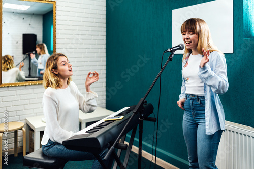 Vocal coach training her student's voice on a lesson
