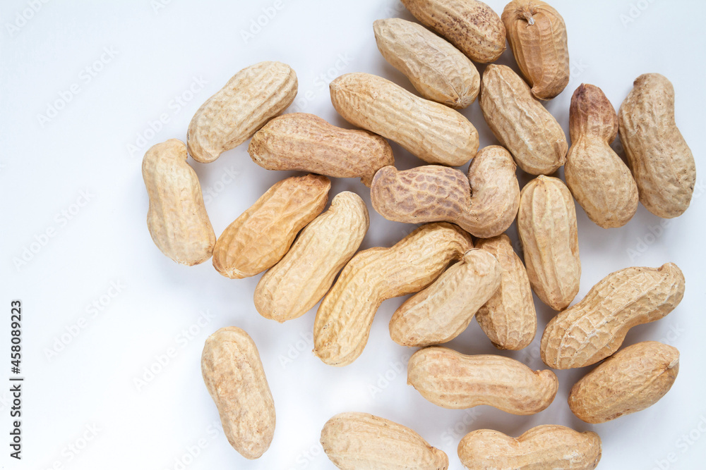 Peanuts (Monkey nuts), unpeeled, in their hard shells. Nuts flat lay composition on a white background. Peanuts (Monkey nuts), unpeeled, in their hard shells. Nuts flat lay composition on a white background.