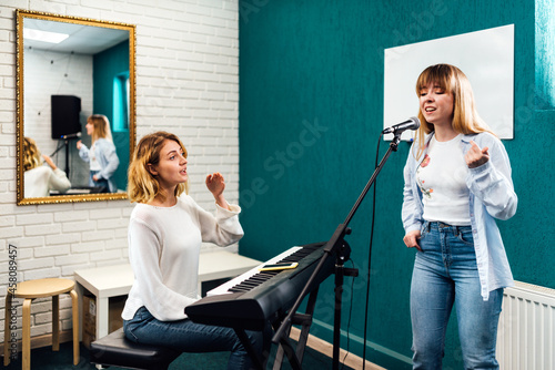 Woman vocalist singing in microphone on a vocal lesson