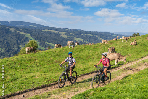 nice and remained young grandmother and her grandson riding their electrc mountain bikes in the Allgaeu Alps near Oberstaufen in Bavaria, Germany