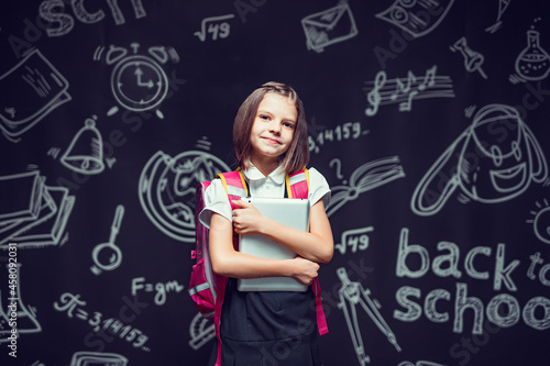 Cute pupil preparing to go to school with backpack and tablet in hands. Back to school concept  © zamuruev