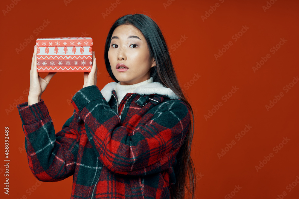 woman of asian appearance in winter clothes gift for christmas isolated background woman of asian appearance in winter clothes gift for christmas isolated background