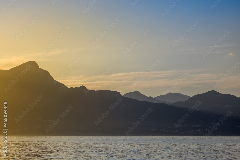 Italy - Lake Garda in the town of Torri del Benaco. A sunset, a romantic place by the water, with mountain peaks in the distance.