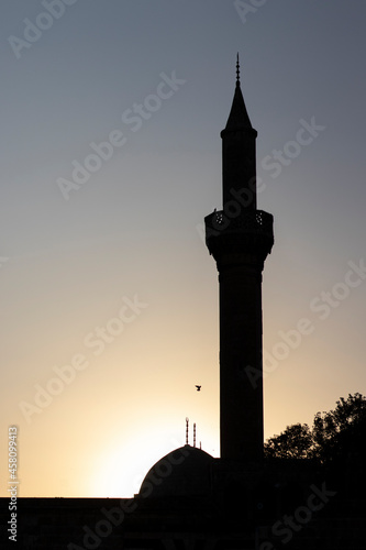 Silhouette of a mosque with a tall minaret at sunset.  Urfa  Turkey. 