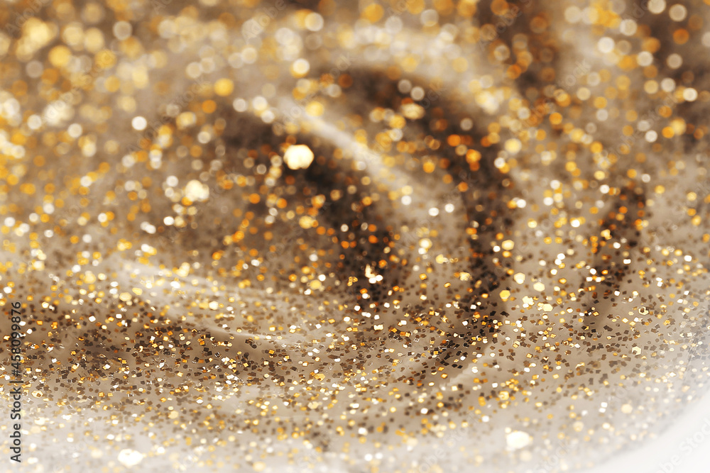 Shiny gold glittering background with soft selective focus. Nail polish texture. Shiny gold glittering background with soft selective focus. Nail polish texture.