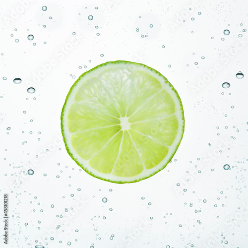 Slice of lime is in the water bubbles