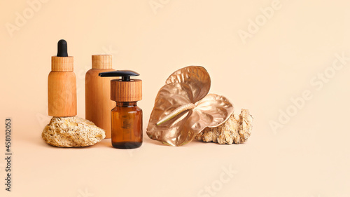 Composition from the natural stones,golden flamingo flower and wooden cosmetics containers.Concept of the organic,zero waste materials.Beautiful beige palette,large banner with copy space.