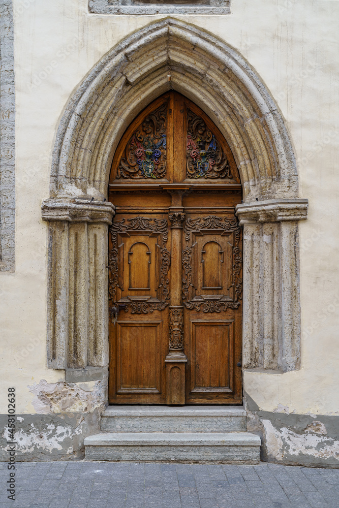 Very old door in stone arch with medieval style.