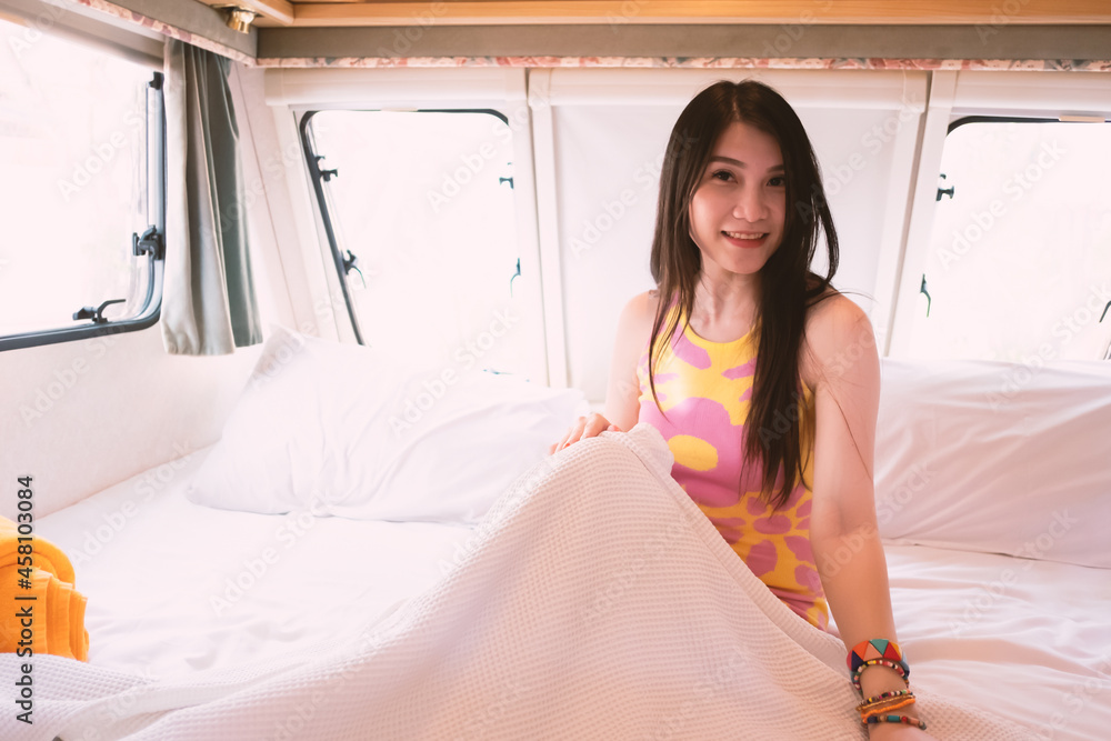 Pretty lady on bed in caravan, camping car, RV road trip tourist ...